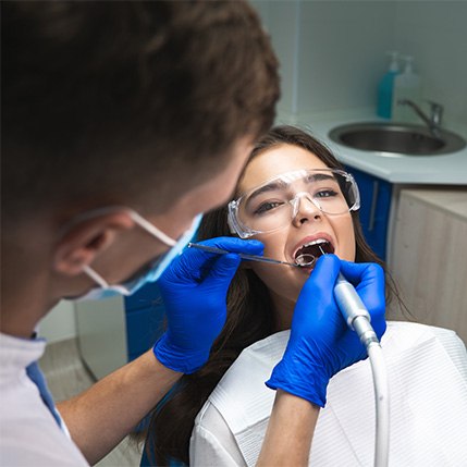 A dentist performing a root canal on a woman