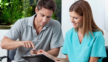 A man using a credit card to pay for root canal treatment