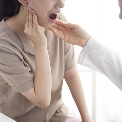 Doctor examining woman with symptoms of TMD